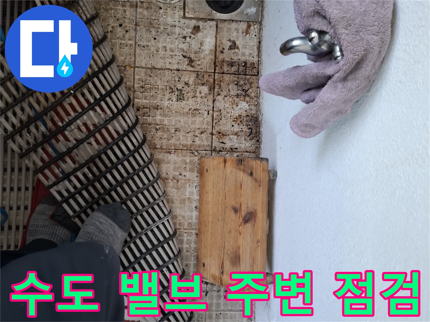주방 수도꼭지 아래쪽의 배관 연결 및 타일 상태 사진