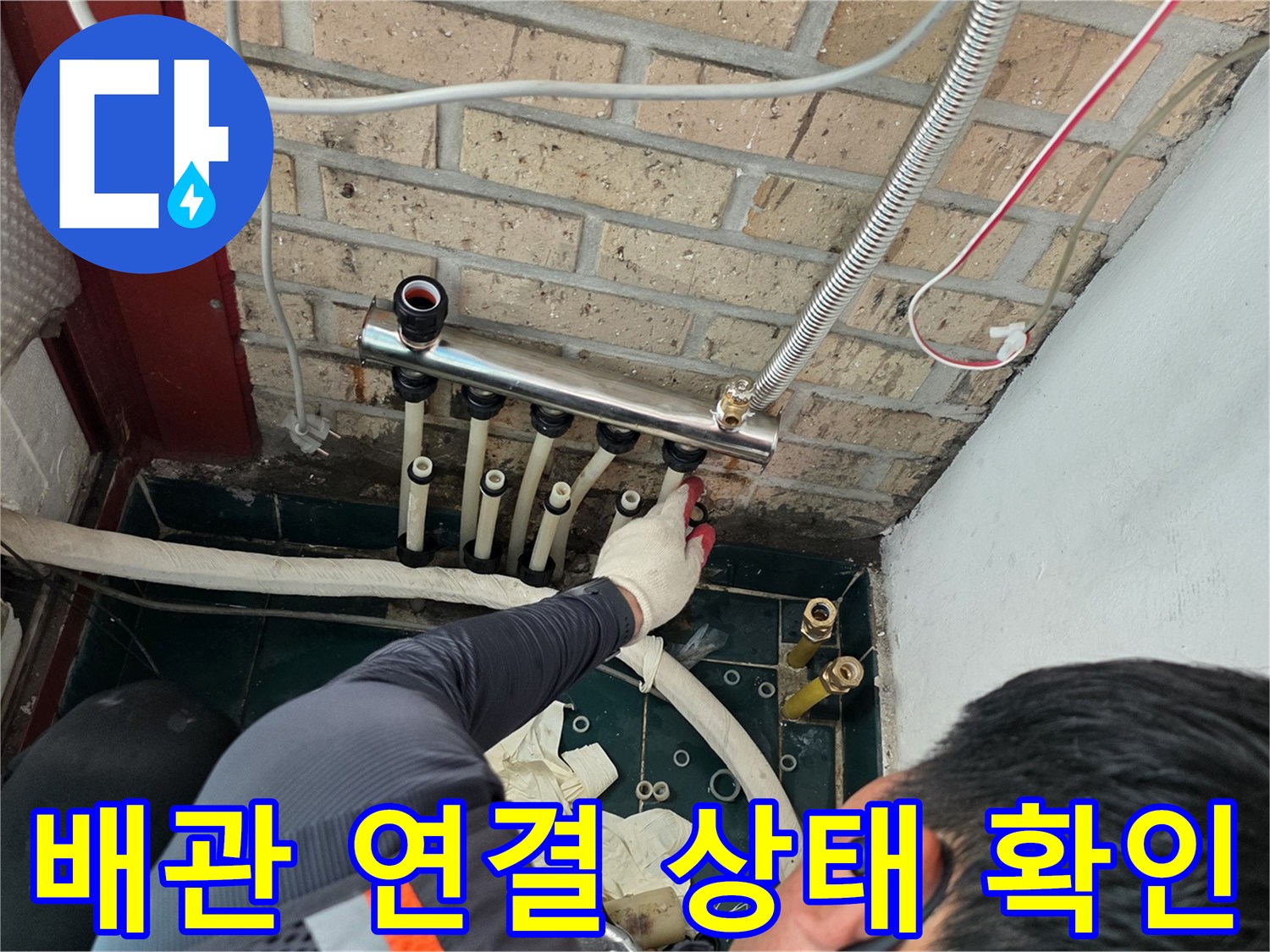 벽돌 벽면 아래 위치한 금속 분배기와 배관 구조물