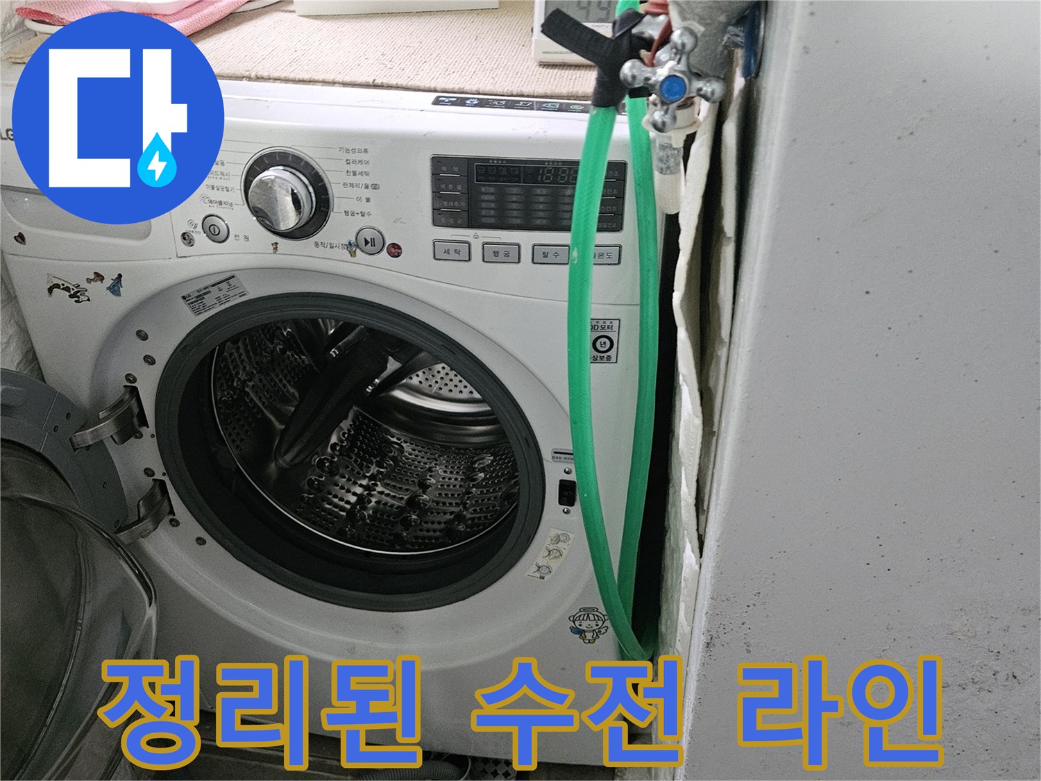 세탁실 벽면 수전과 초록색 급수 호스가 연결된 모습입니다.
