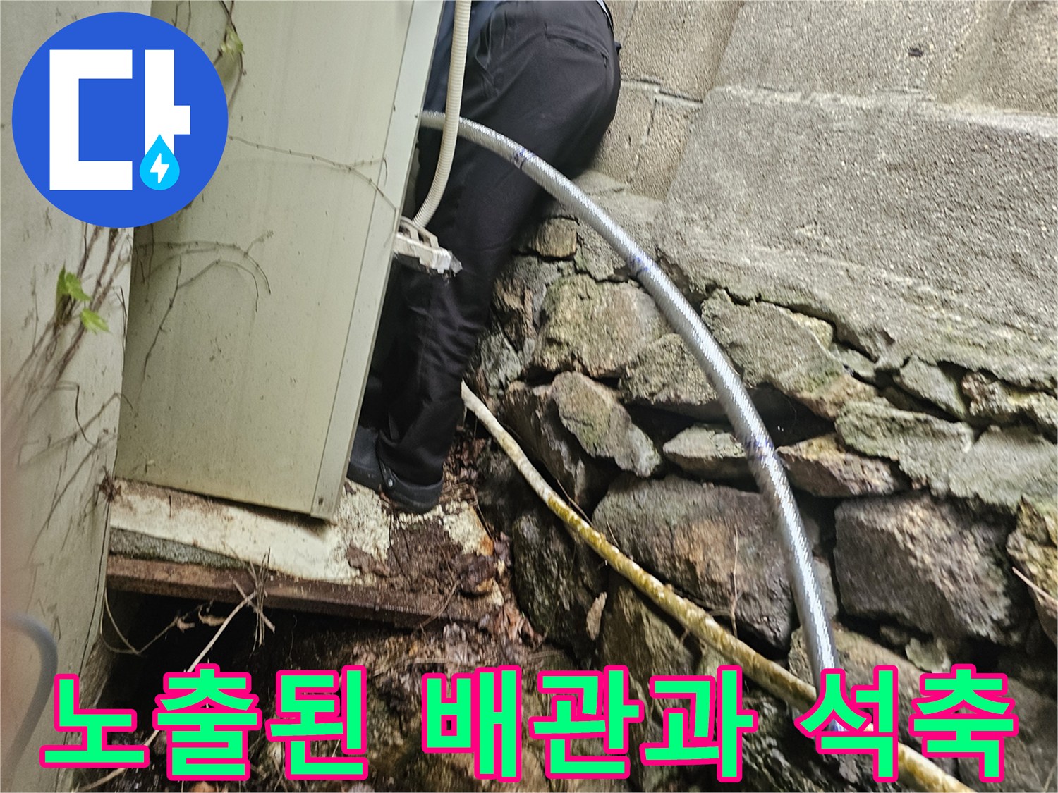 석축 틈새를 통해 드러난 보온재 감긴 배관의 모습