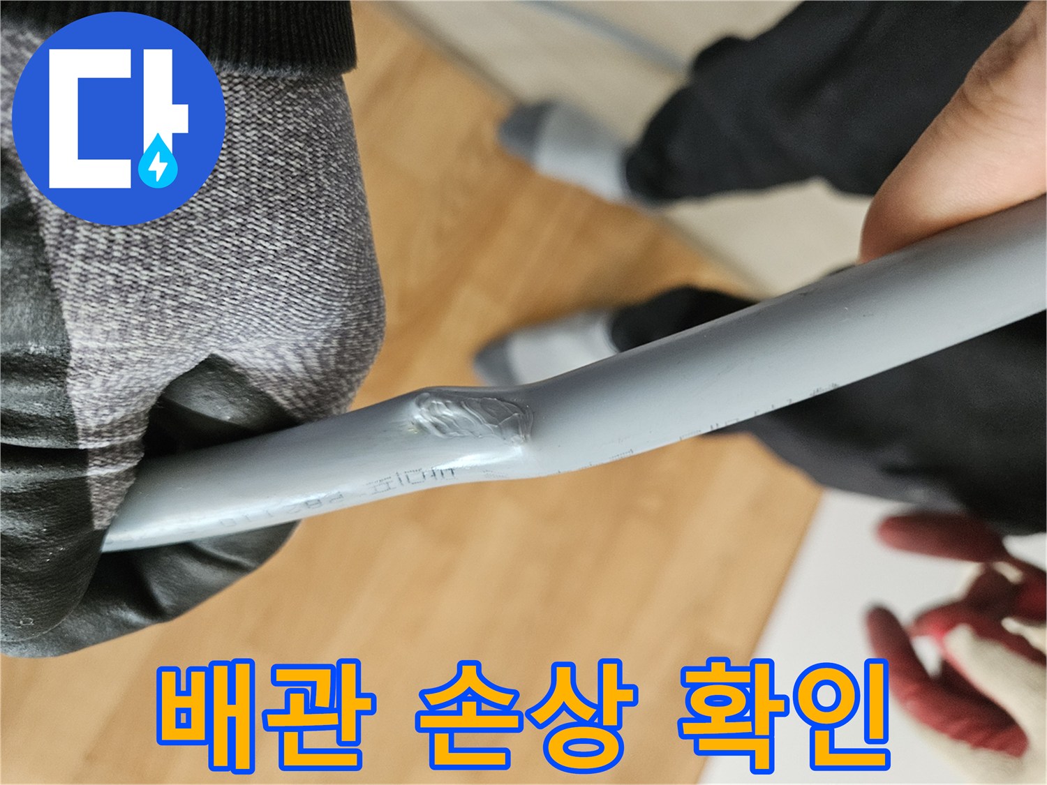 회색 배관의 굴곡진 파손 부위 근접 촬영