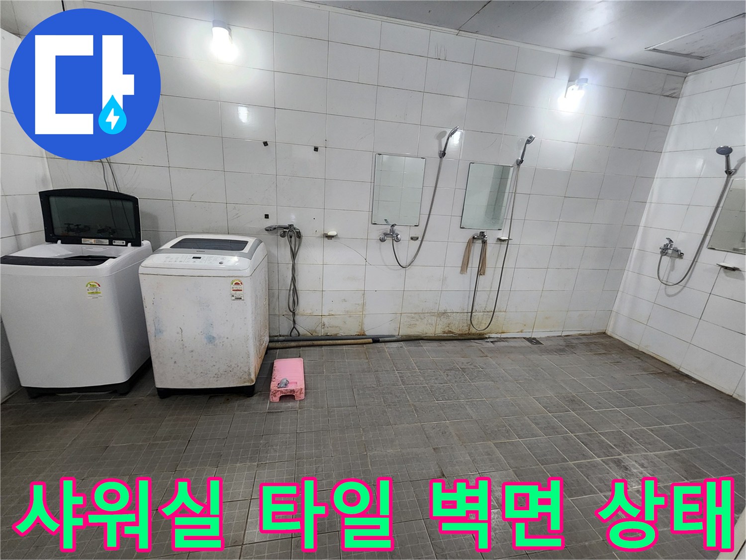 샤워기 수전과 세탁기가 위치한 화장실 벽면의 타일 및 배관 연결부 사진