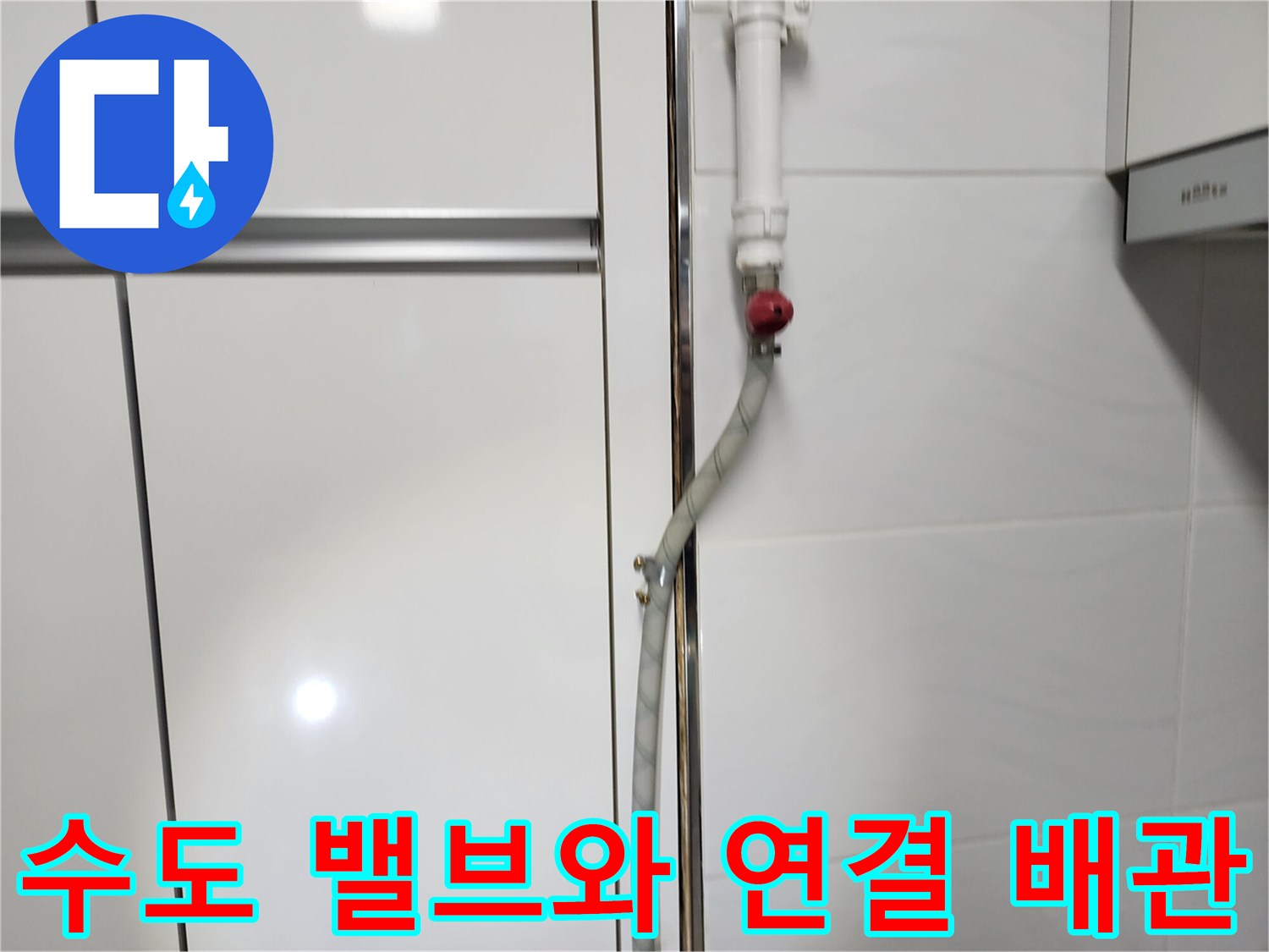 벽면에 설치된 수도 밸브와 은색 주름관의 모습