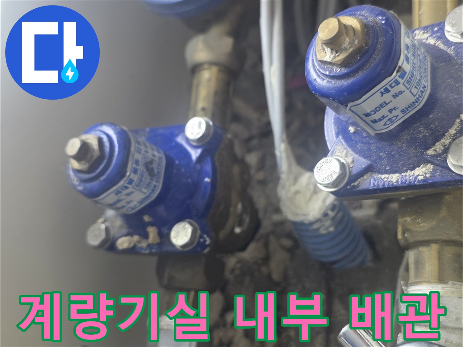 수도 계량기와 은색 밸브가 포함된 배관 연결부