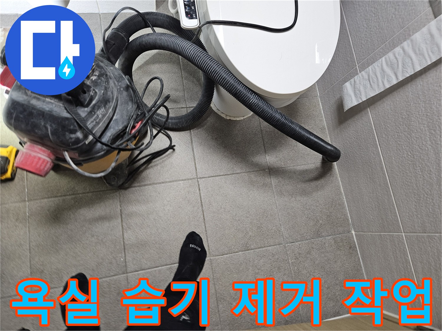 오산시 고객 댁 욕실에서-누수 엔지니어가-변기 주변의 습기를-습식 청소기로 제거하며-누수탐지 준비를 하는 모습