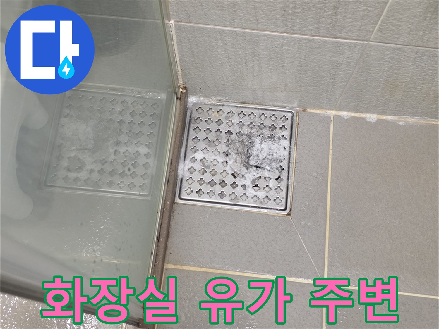 욕실 타일과 배수구 사이의 틈새를 근접 촬영한 사진입니다.