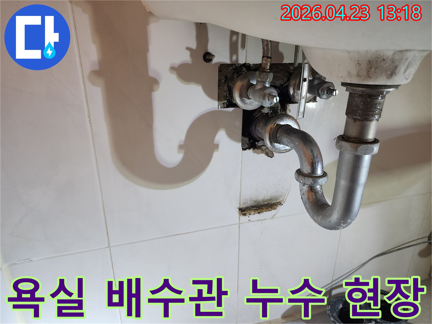이 이미지는 양주 삼숭동 아파트 욕실 세면대 배수관에서 발생한-누수로 인해 벽면에 생긴 물자국과 곰팡이 흔적을 보여줍니다.