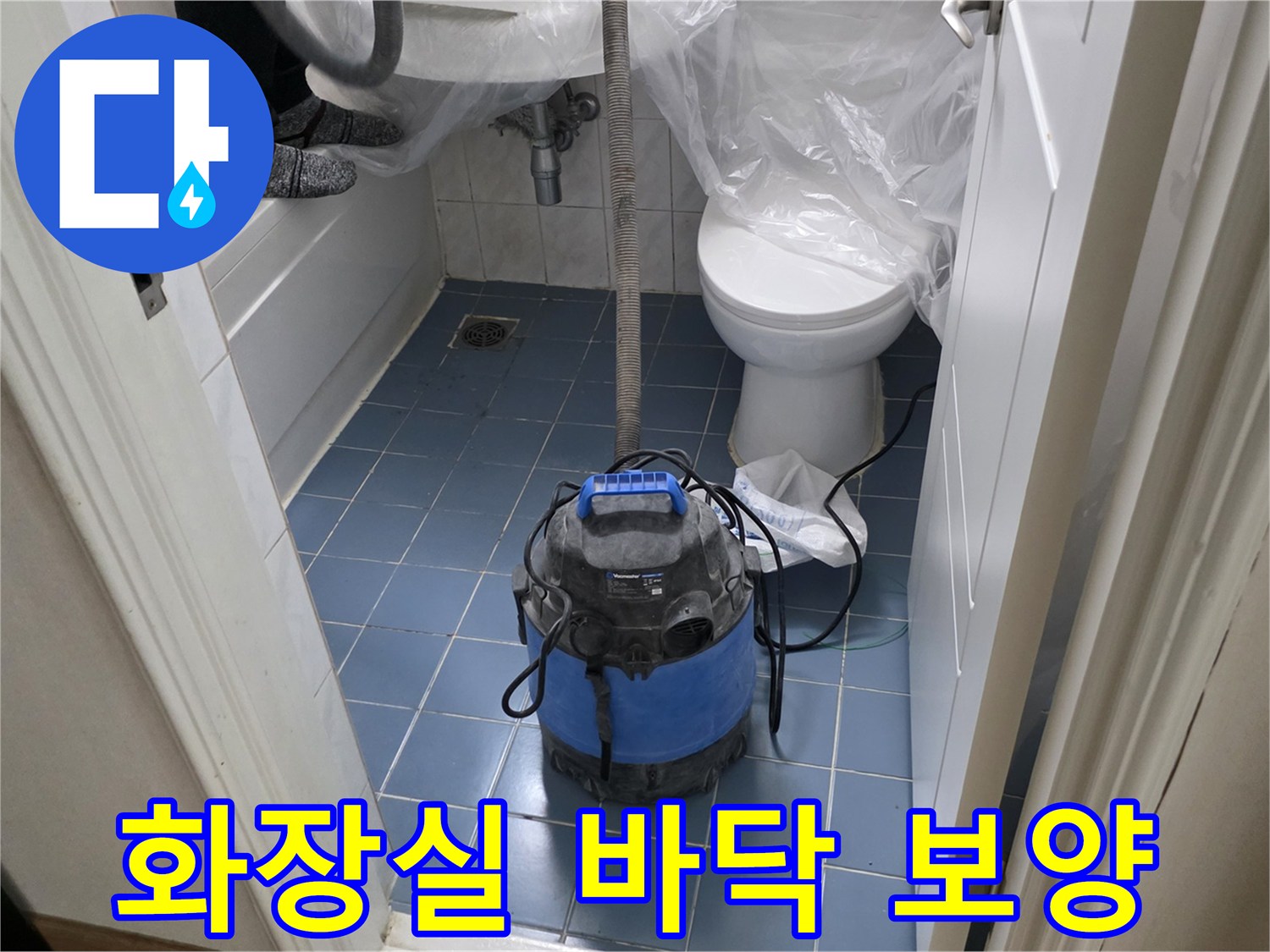 청소기와 비닐로 덮인 화장실 내부의 작업 준비 모습
