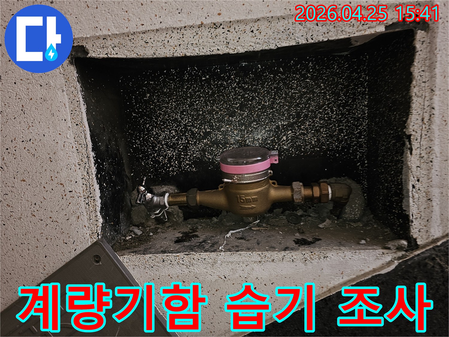 수도계량기함-내부에-발생한-습기의-원인을-파악하기-위해-계량기와-주변-배관을-면밀히-조사하는-모습입니다