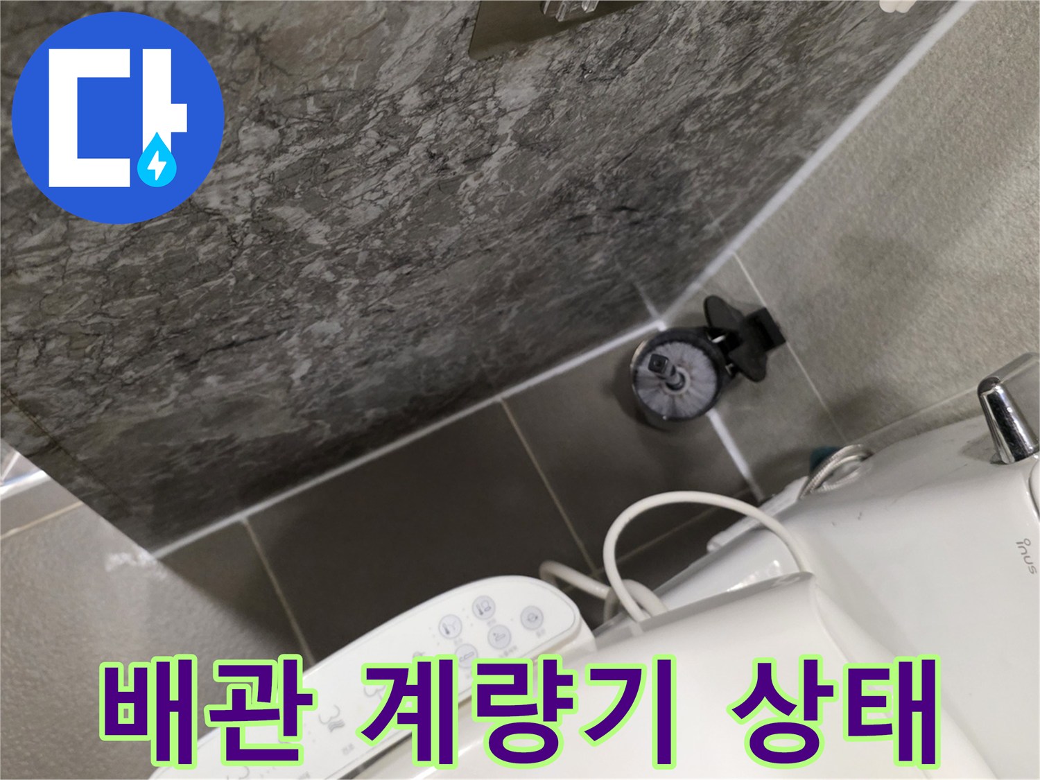 화장실 벽면 타일과 수도 계량기의 연결 부위