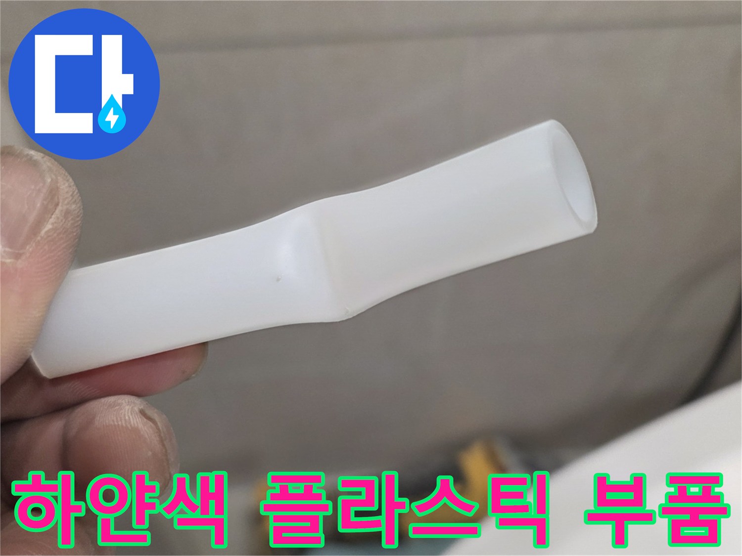 손가락으로 잡고 있는 파손된 흰색 배관 연결재