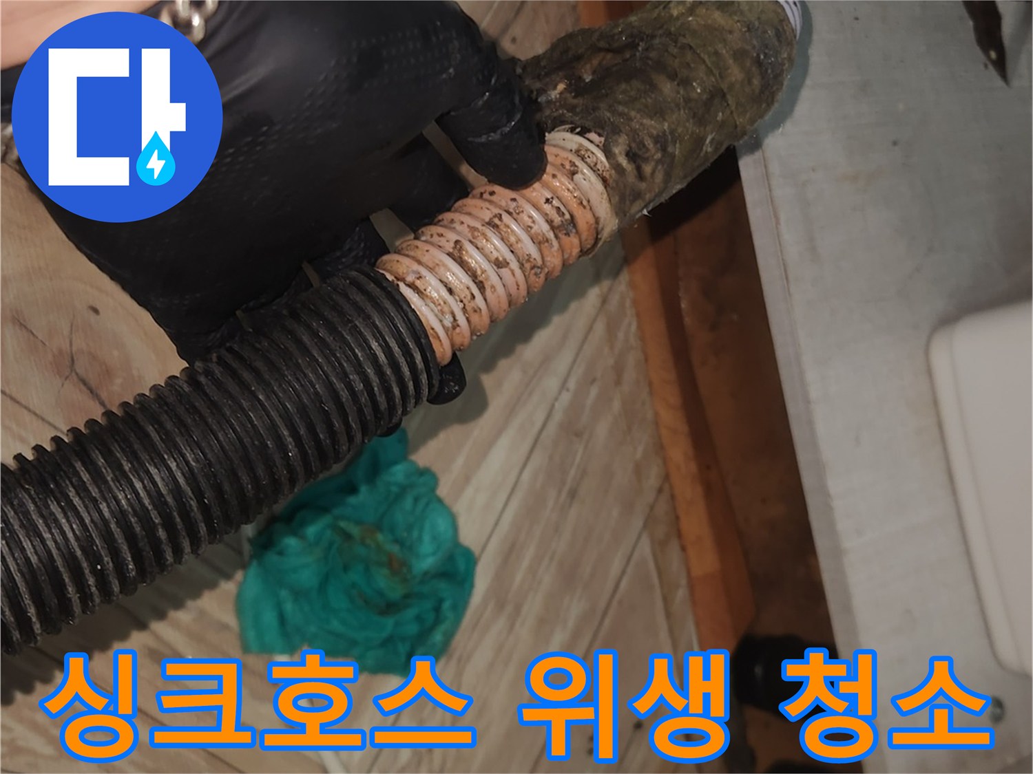 전문 엔지니어가-검은 장갑을 착용하고-오염된 싱크대 배수 호스를-석션 클리닝하기 위해-잡고 있는 클로즈업 사진
