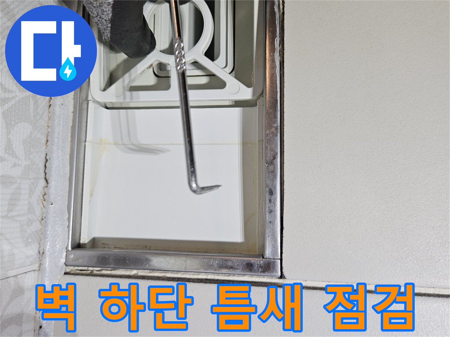 누수 전문가가-특수 도구를 사용하여-벽면 하단부의-미세한 틈새를-집중적으로-점검하는 사진입니다