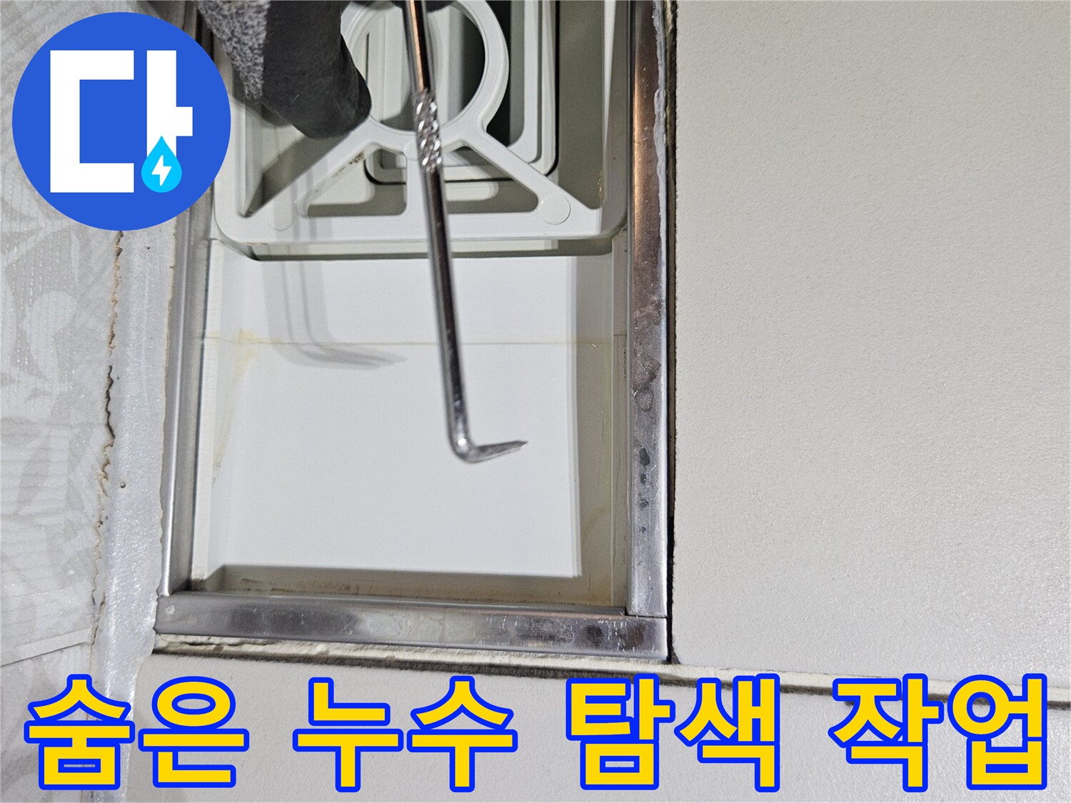 누수 전문가가-특수 도구를 사용하여-벽면 하단부의-숨겨진 누수 지점을-탐색하는 장면입니다