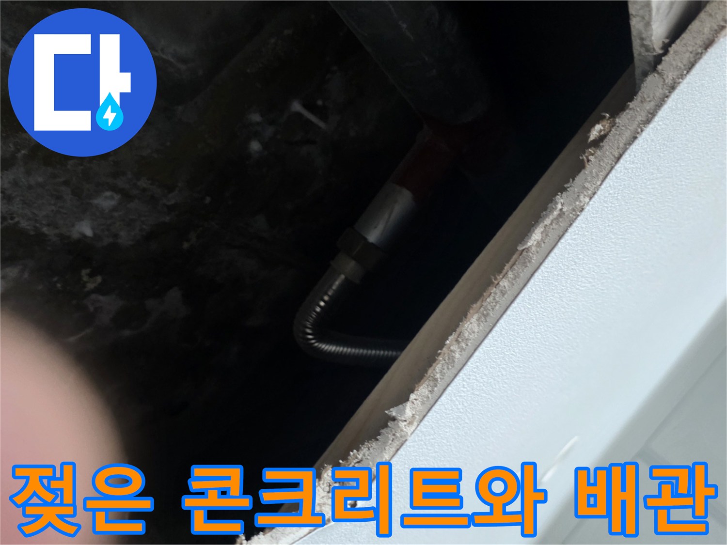 배관 주변의 젖어 있는 콘크리트 슬래브와 유연한 연결관 모습