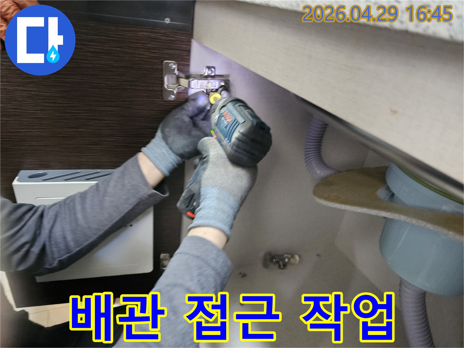 누수 엔지니어가-배관에 접근하기 위해-싱크대 하부장-패널을-분리하는-작업