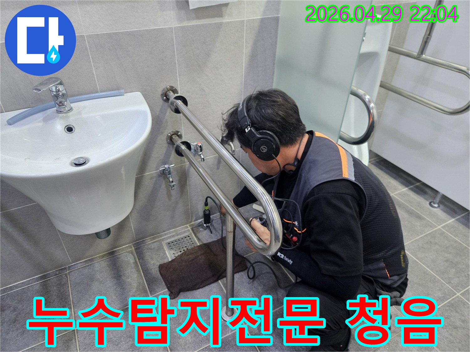 누수 탐지 전문가가-청음식 장비로-수도 배관의-미세한 누수음을-정밀하게 듣는 모습