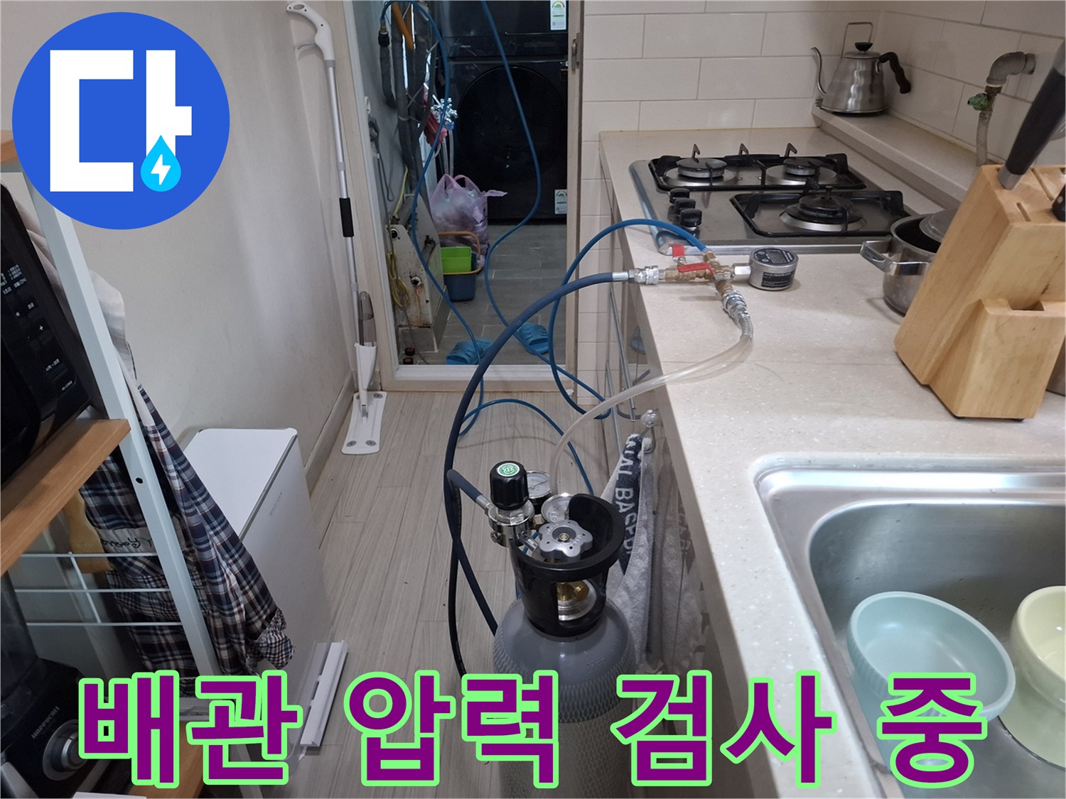 싱크대 하부 배관에 연결된 가스 탐지 장비와 압력 조절 밸브의 상세 모습입니다.
