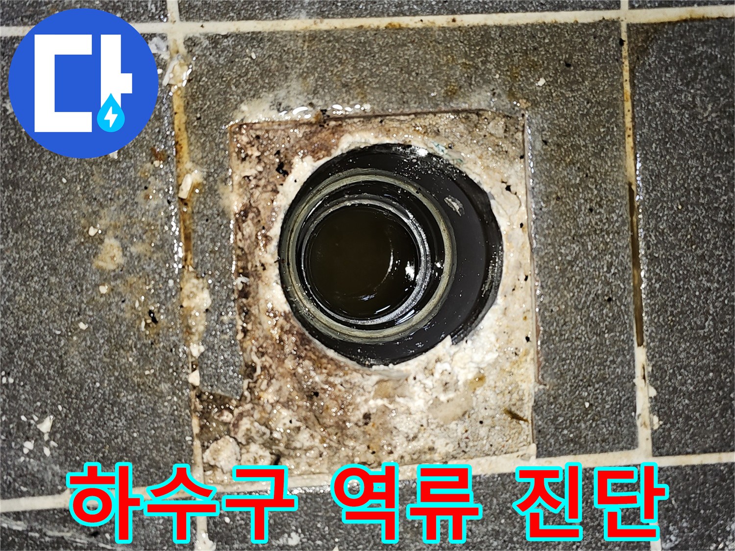 하수구에서 물이 역류하여-바닥에 고여있는 모습을 보여주는-심각한 배관 막힘 현장의 사진입니다.