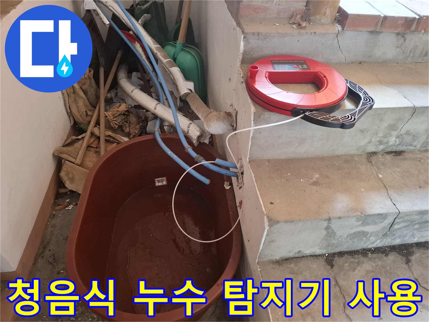 계단 옆 공간에 놓인-붉은색 청음식 누수 탐지기