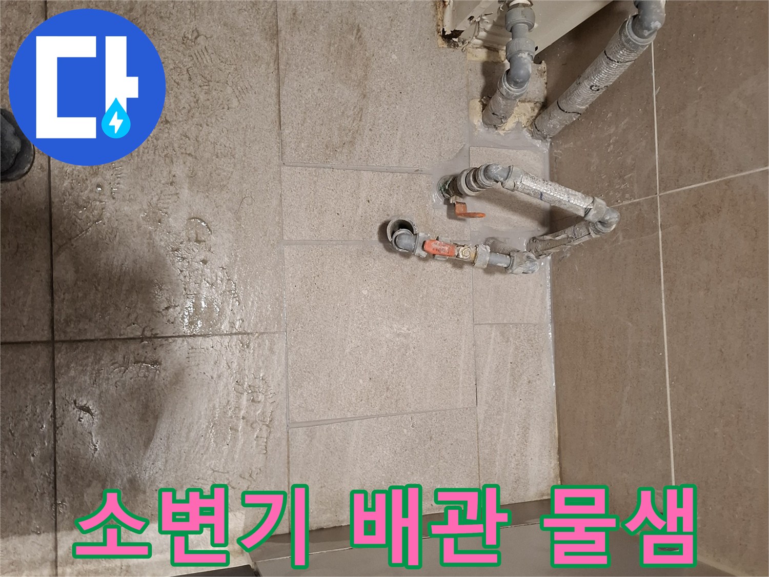 소변기 주변-노출된 배관과 젖은 바닥 타일 상태