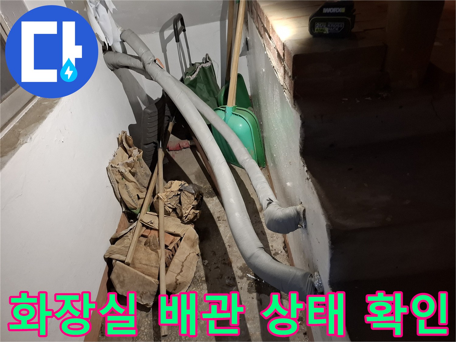 회색 배관과 바닥에 놓인 작업용 자재들