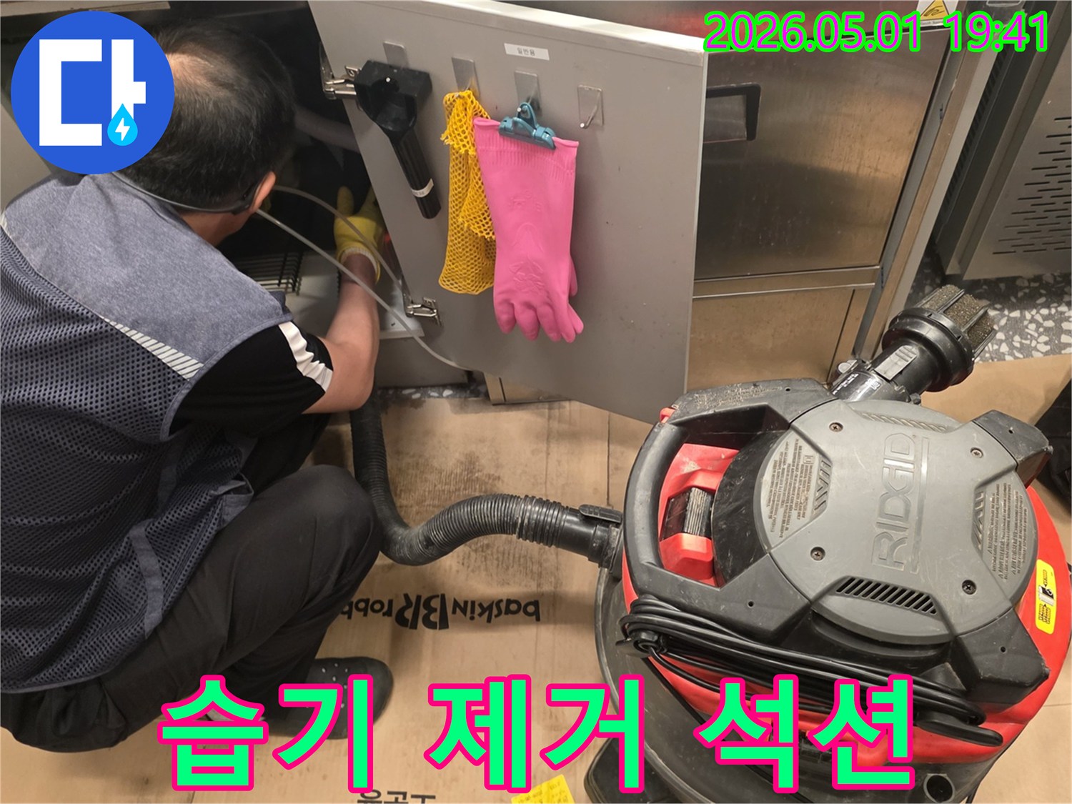 습기-제거를-위해-산업용-청소기를-사용하여-누수-현장을-정리하는-모습
