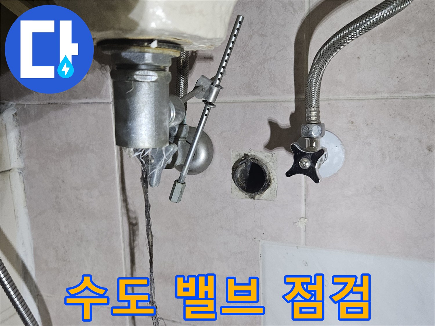 벽면에-설치된-수도-밸브와-은색-자바라-호스
