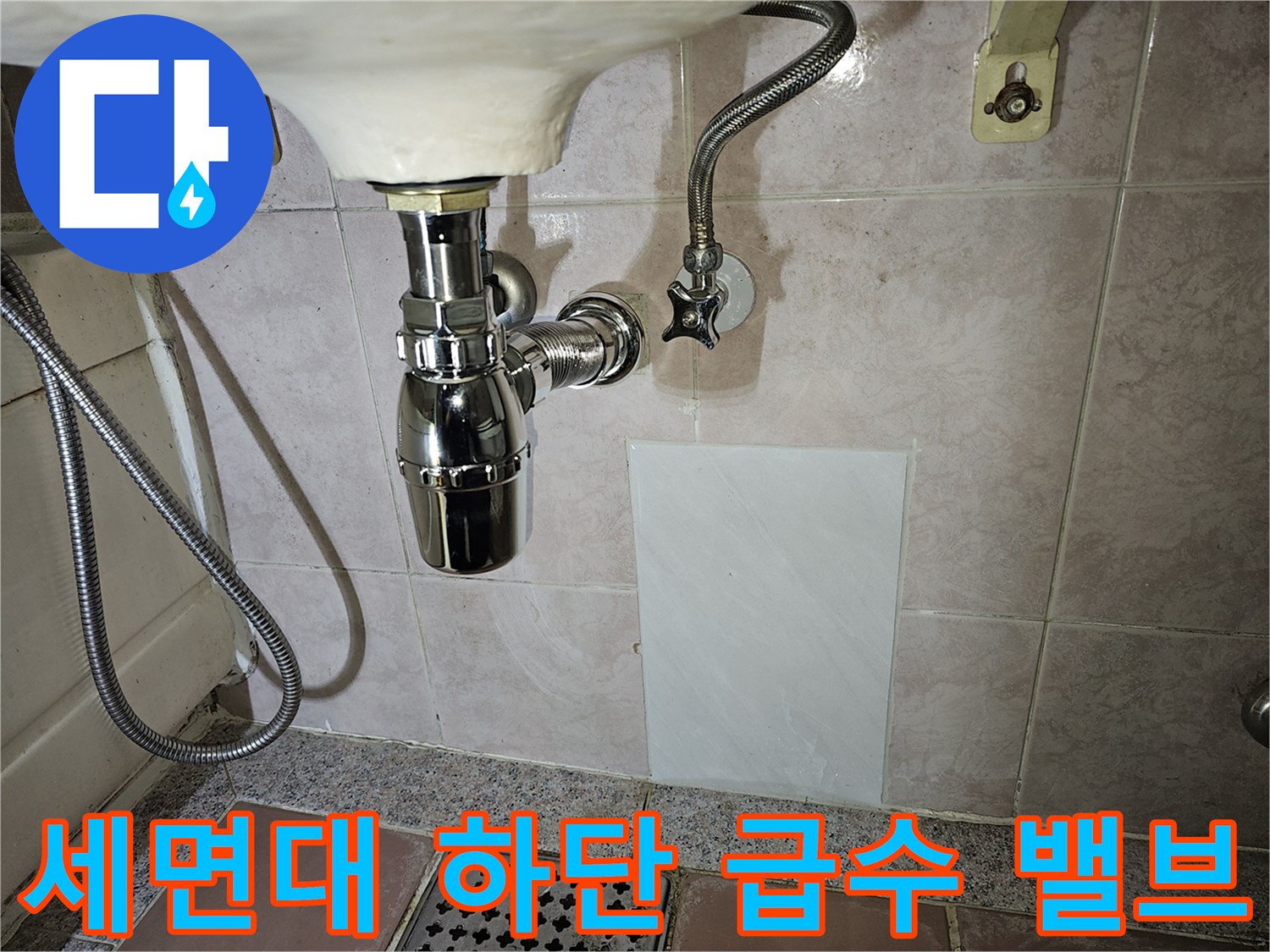 세면대 아래 벽면에 설치된 수도 부속품 모습