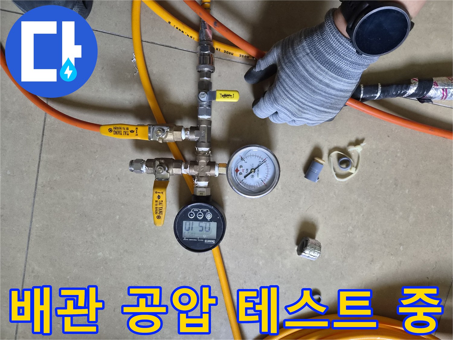 배관 연결 부위에 설치된 압력 측정 장비와 노란색 호스