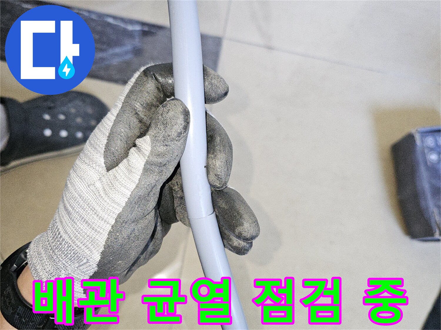엔지니어가 장갑을 끼고 배관의 파손 상태를 확인함