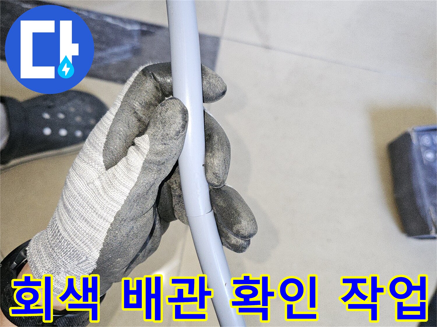 작업용 장갑을 낀 손으로 파손된 배관을 지탱하며 점검하는 장면