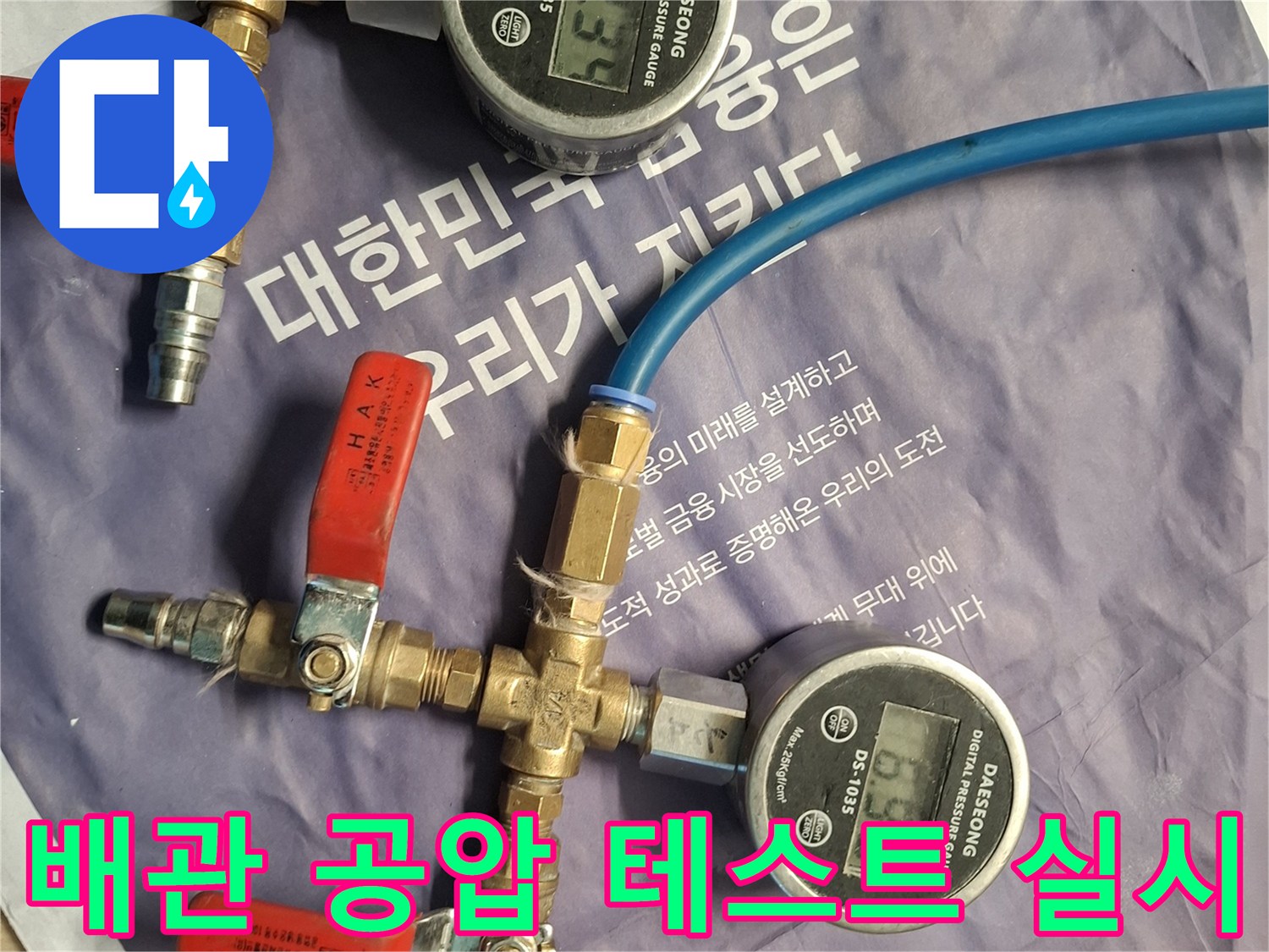 배관 연결 부위와 디지털 압력계가 설치된 작업 사진입니다.