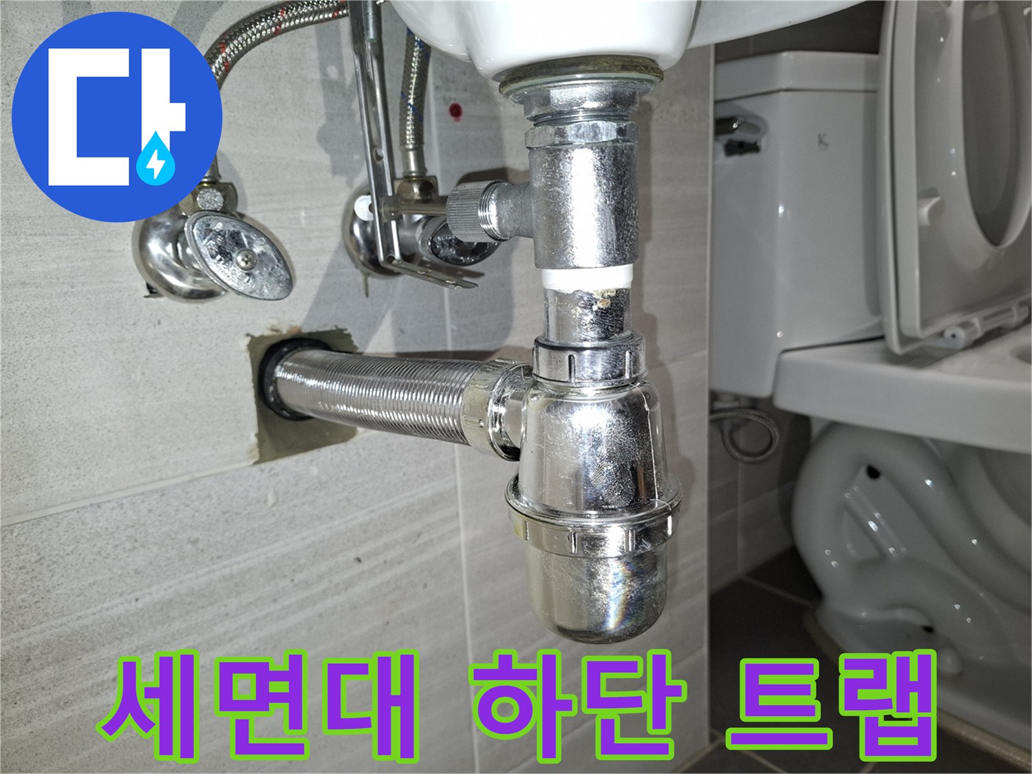 세면대 아래 은색 주름관과 벽면 급수 밸브의 상세 모습