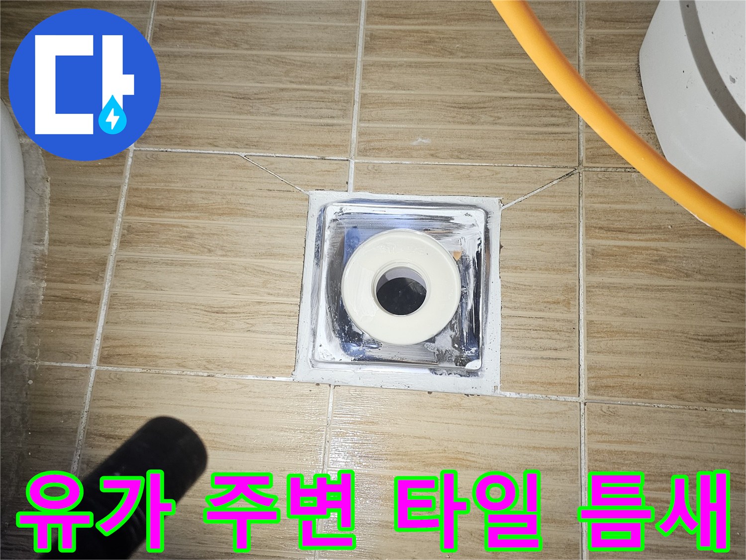 욕실 바닥 배수구 유가 주변의 파손된 타일과 노출된 하수관 모습