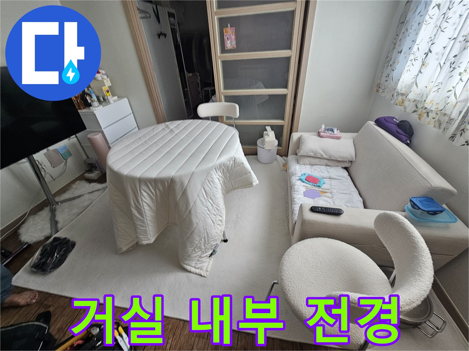 식탁과 소파가 배치된 아파트 거실의 일상적인 풍경입니다.