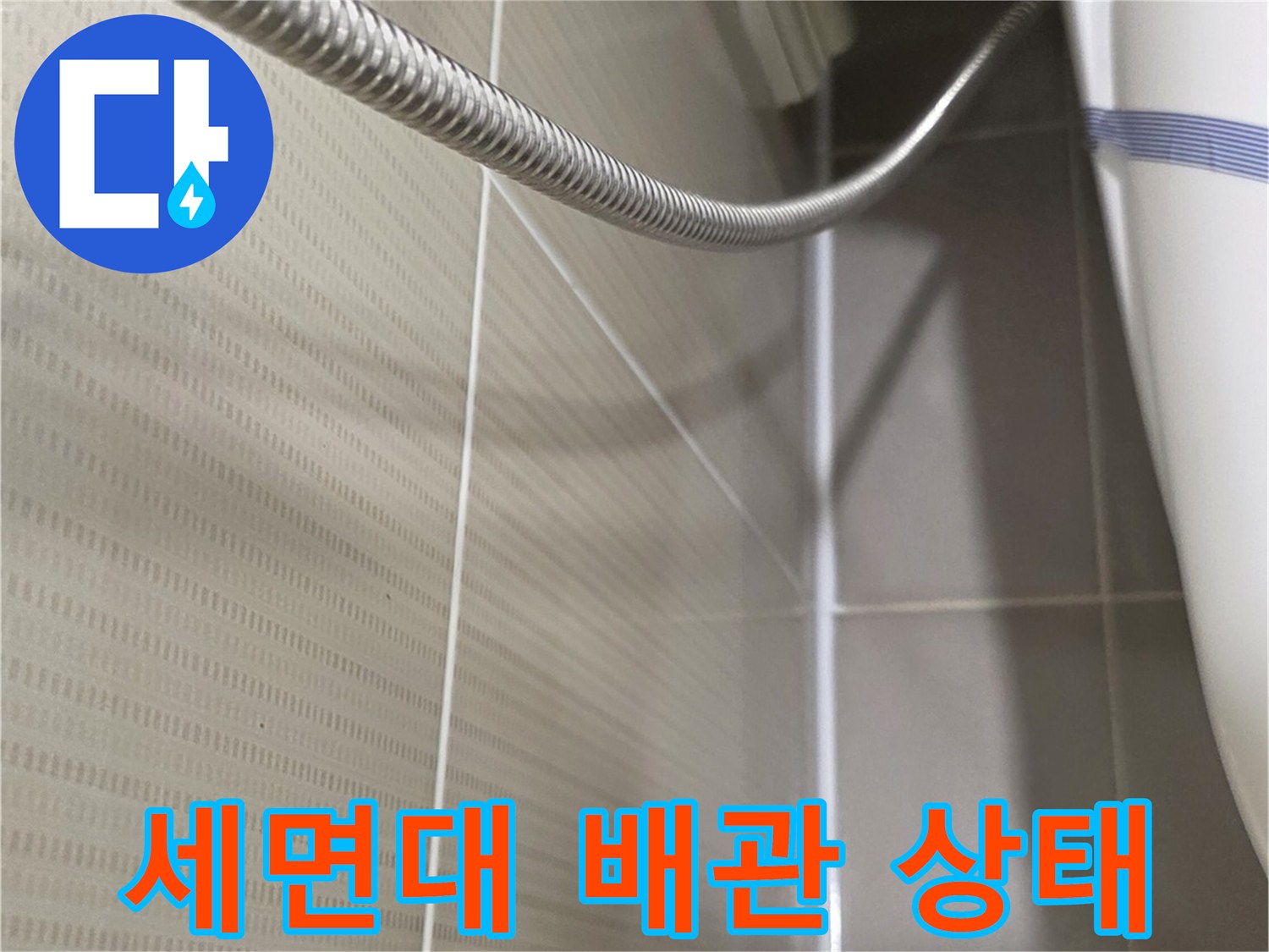 욕실 타일 벽면과 세면대 샤워 호스 근접 촬영