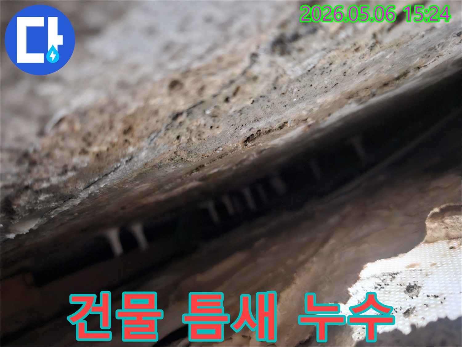 건물-틈새-안쪽에서-발견된-누수로-인한-하얀-석회질-침전물을-확대하여-보여주는-사진입니다
