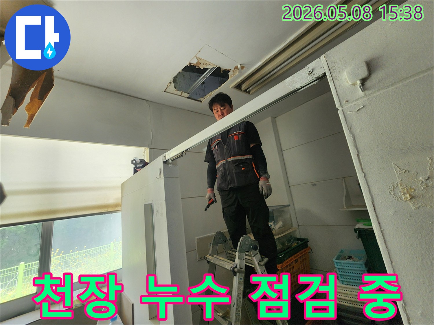 누수 전문가가 사다리 위에서-천장 누수 지점을-세밀하게 검사하고 있습니다