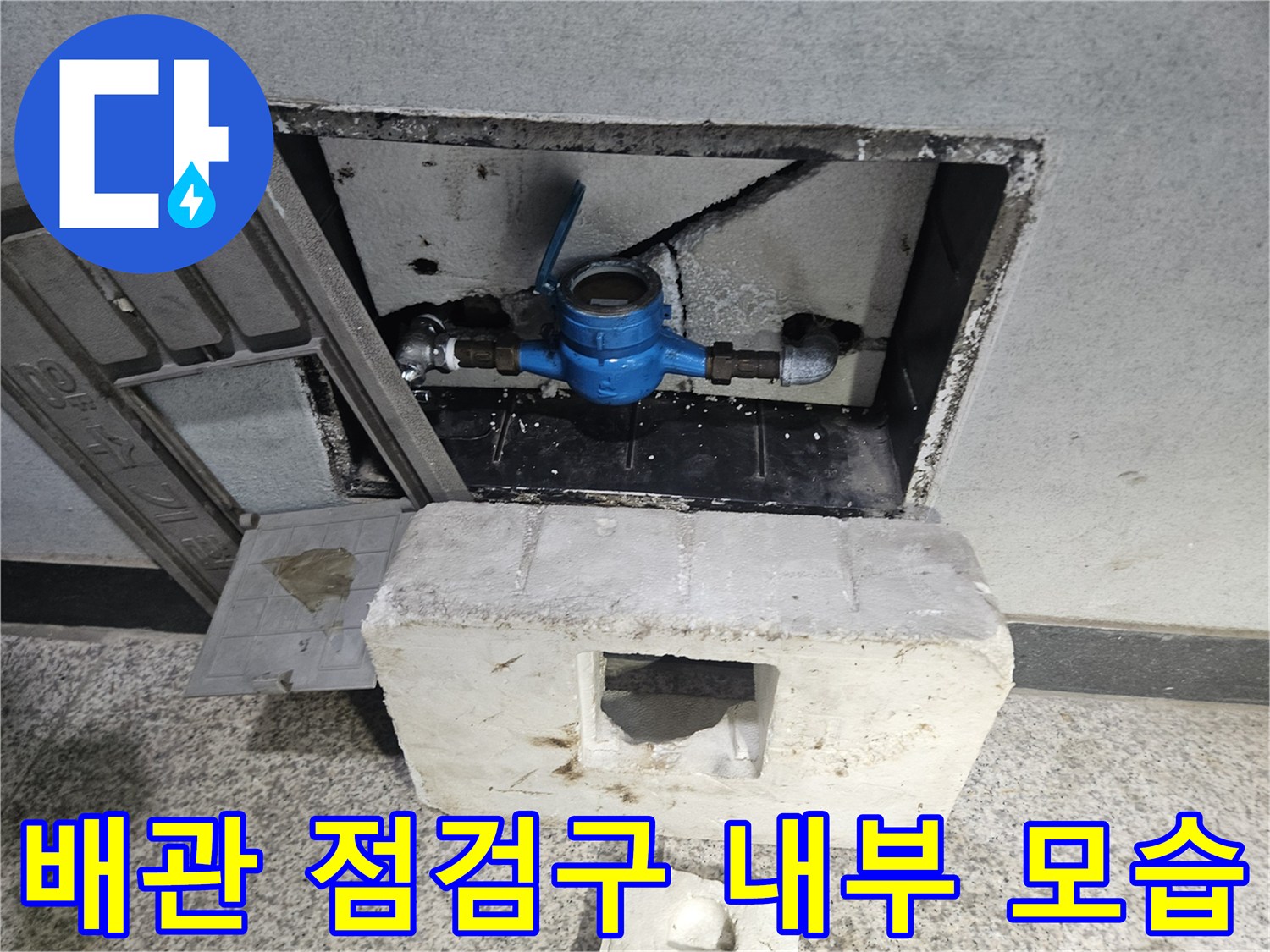 점검구 내부에 위치한 파란색 밸브와 배관 구조