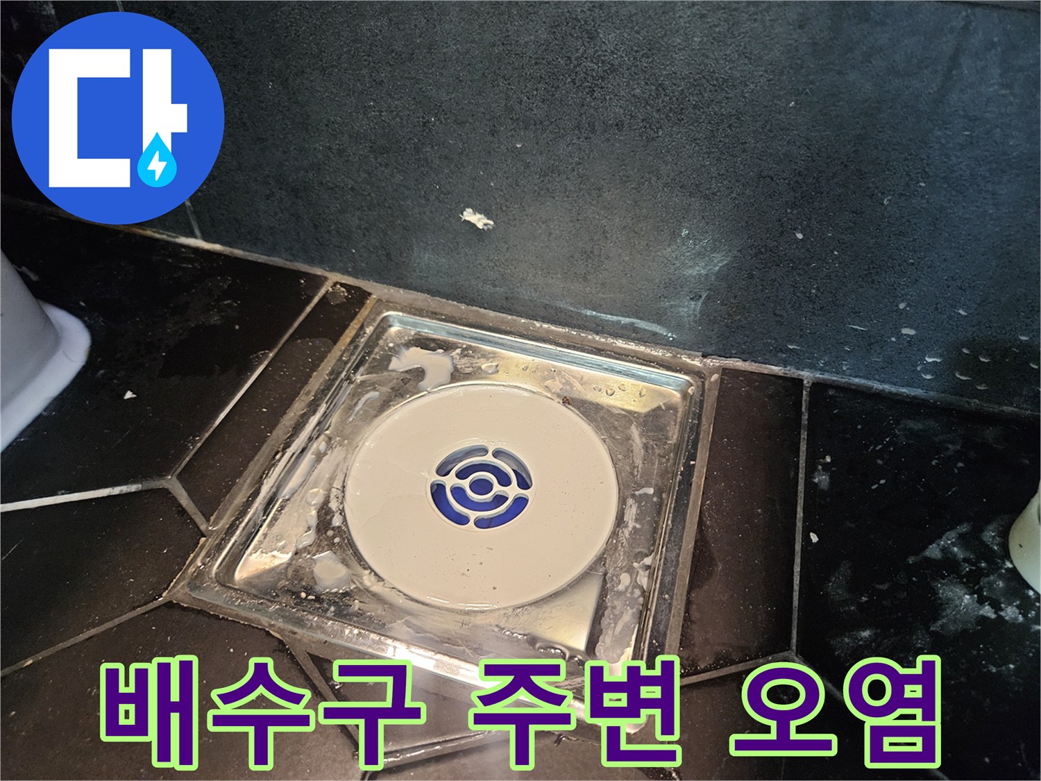 어두운 톤의 타일과 배수구 트랩 근접 촬영
