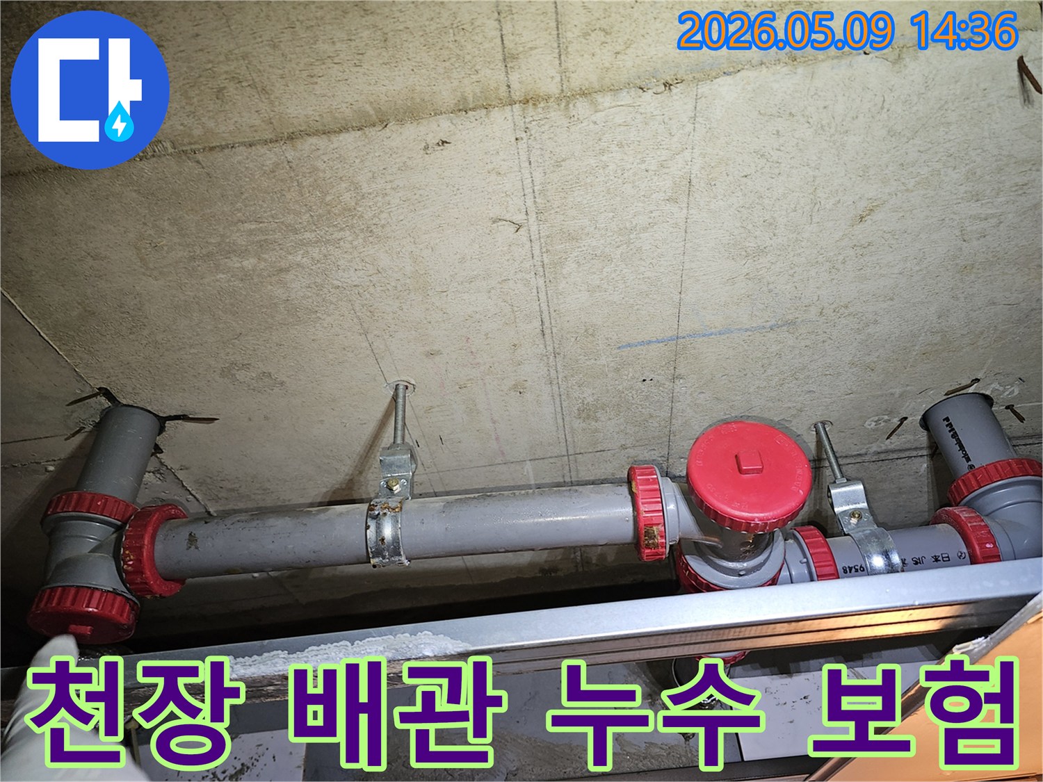 콘크리트 천장에 설치된 배관과-빨간색 밸브를-점검하는 모습