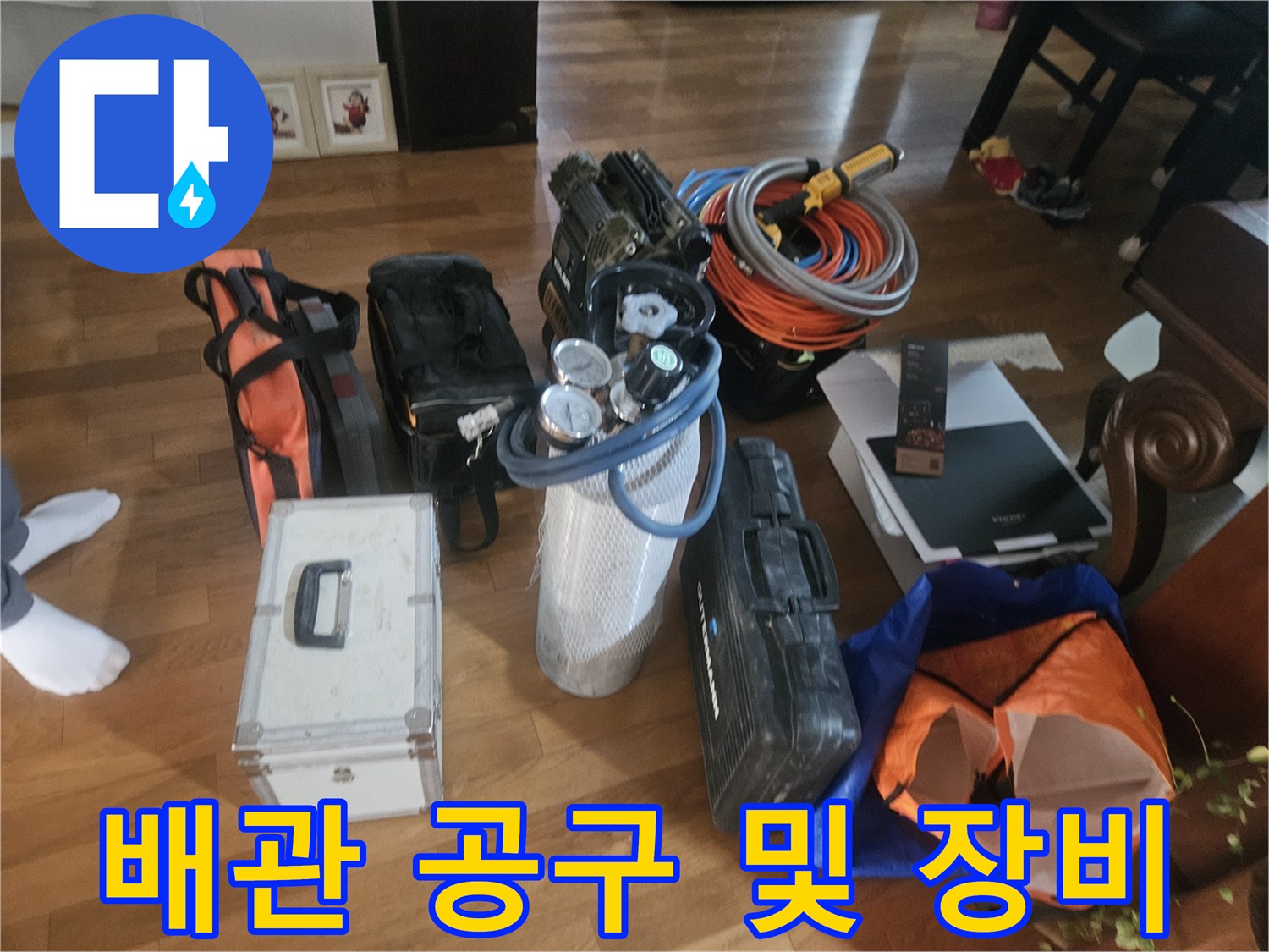 바닥에 펼쳐진 누수 탐지용 압력계와 배관 자재들