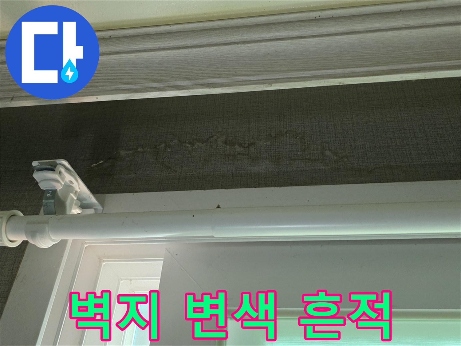 창문 프레임 아래쪽 벽지의 짙은 습기 자국