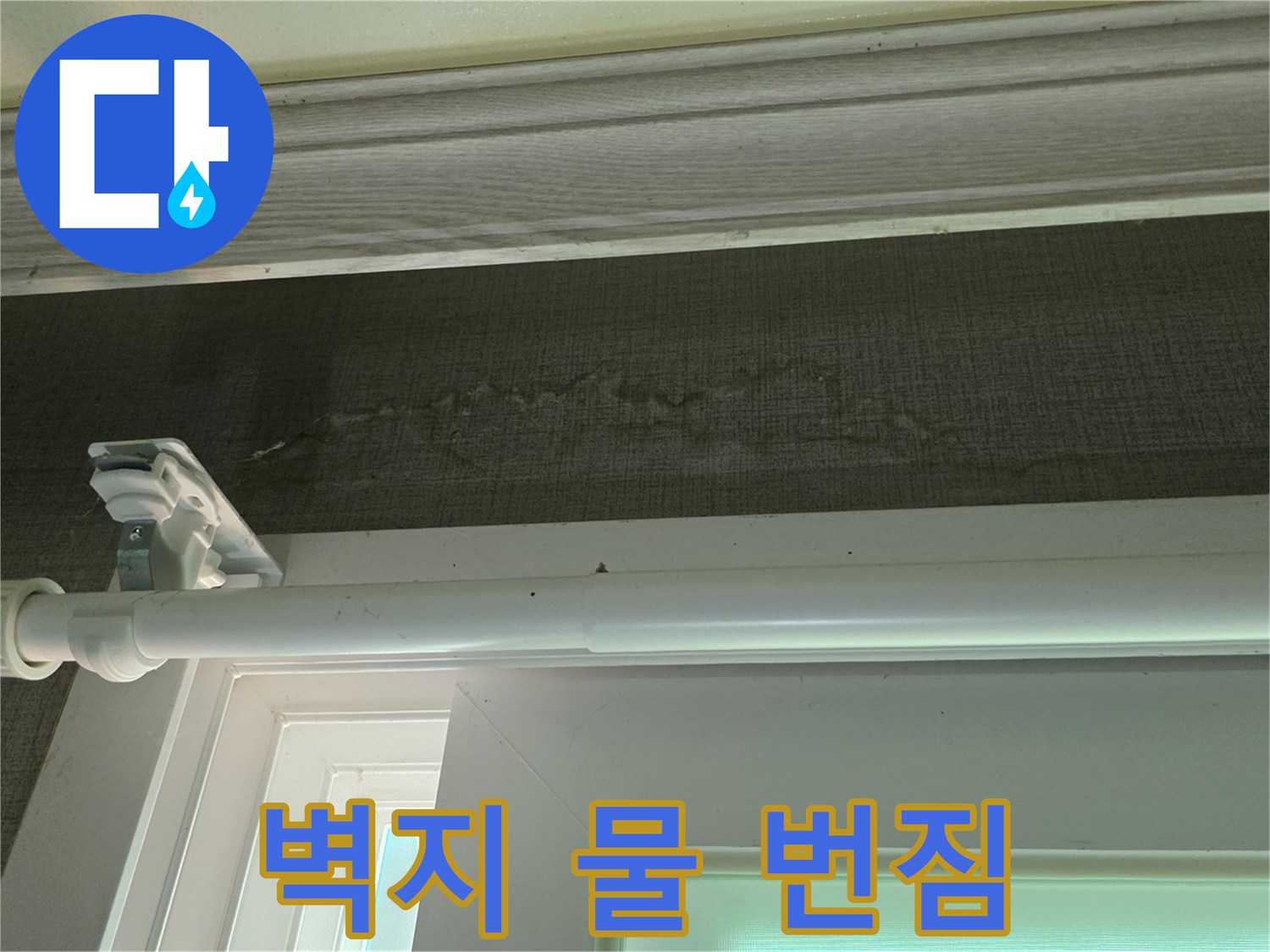 창틀 아래 벽지에 나타난 수분 침투 자국
