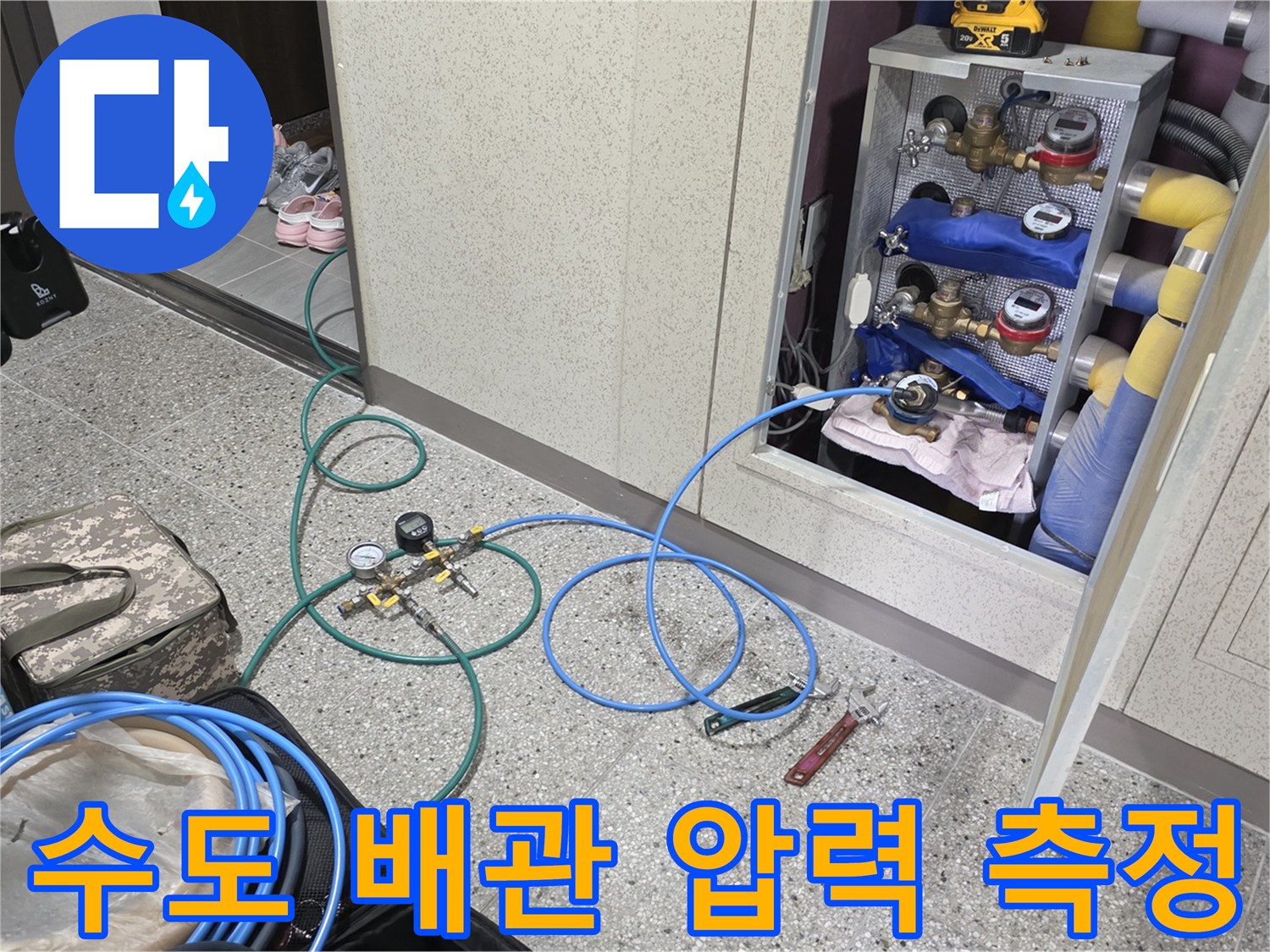 분배기 밸브와 연결된 청색 호스-공압 테스트기를 이용한 배관 누수 진단 중