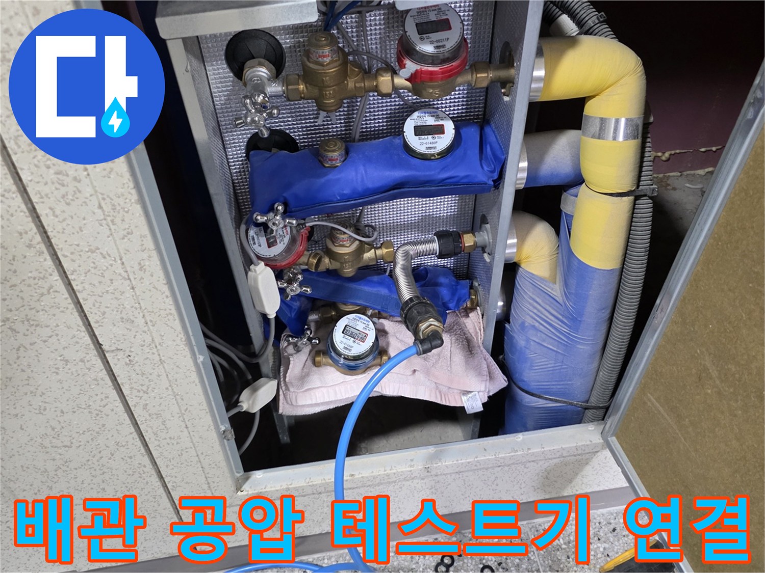 분배기에 연결된 압력 게이지와 파란색 점검 호스