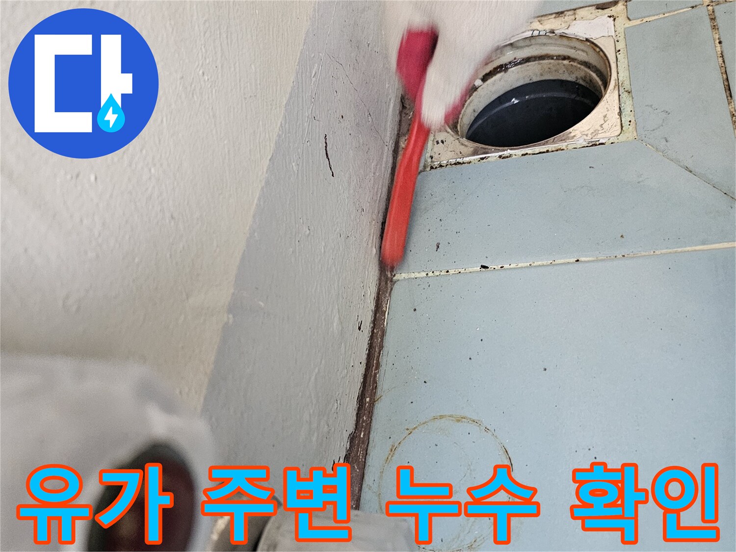 세탁실 배수구 타일 사이의 틈새를 점검하는 모습