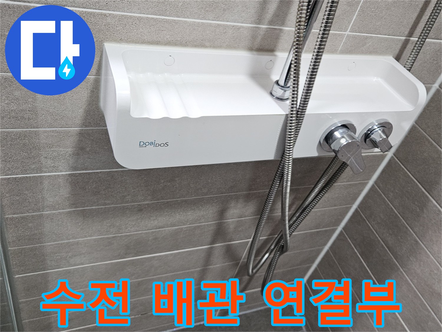 샤워기 수전과 벽 타일 사이의 금속 호스 연결 모습