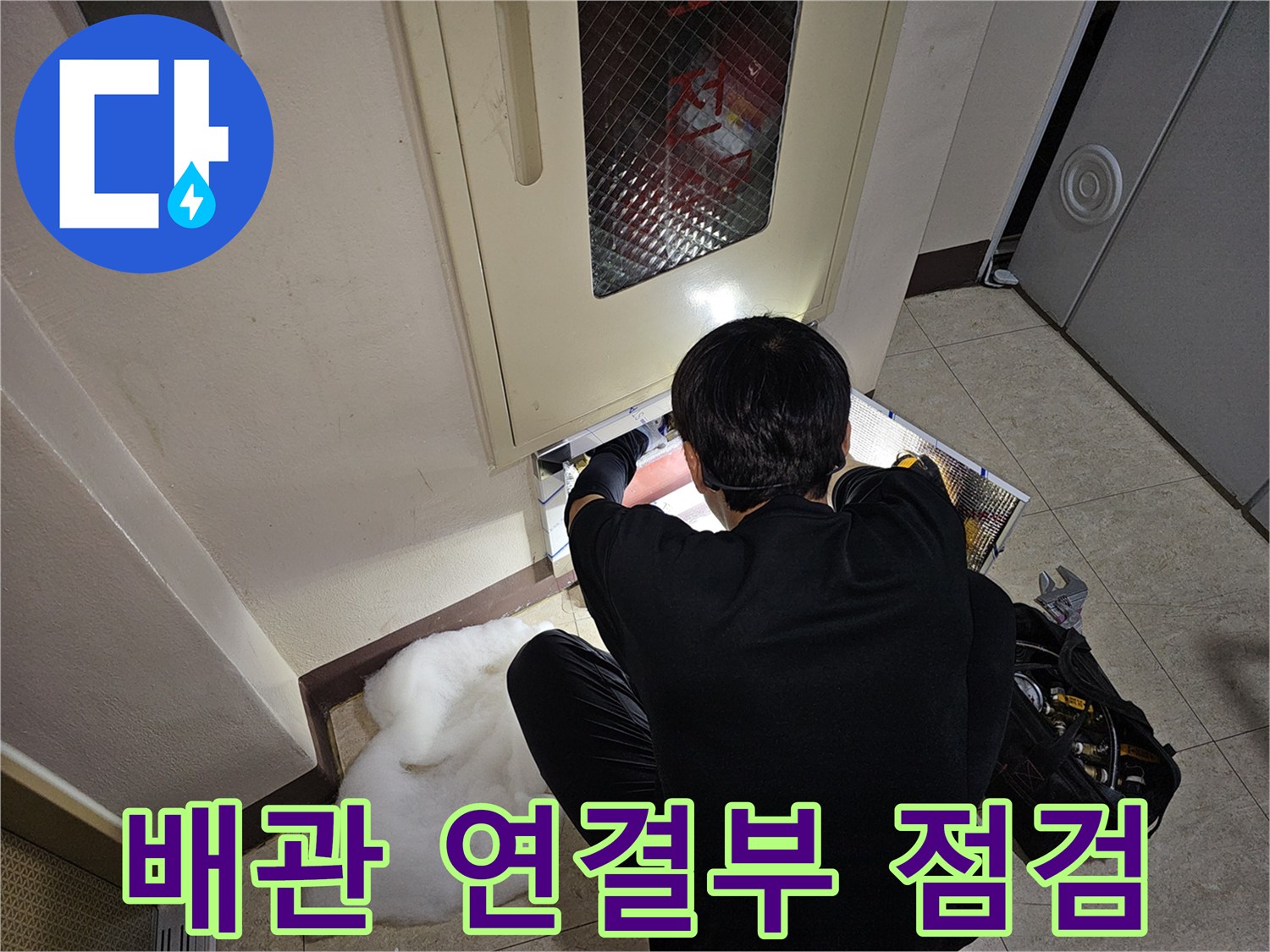 바닥 배관 부위에서-압력 검사를 수행 중인 작업자